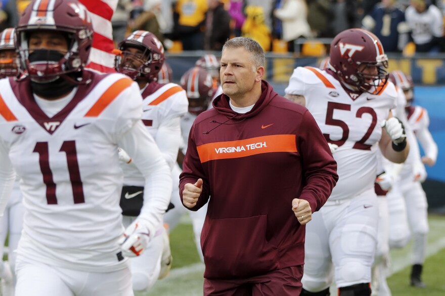 FILE - In this Saturday, Nov. 10, 2018, file photo, Virginia Tech head coach Justin Fuente, center, takes the field with his team before a game against Virginia Tech, in Pittsburgh.