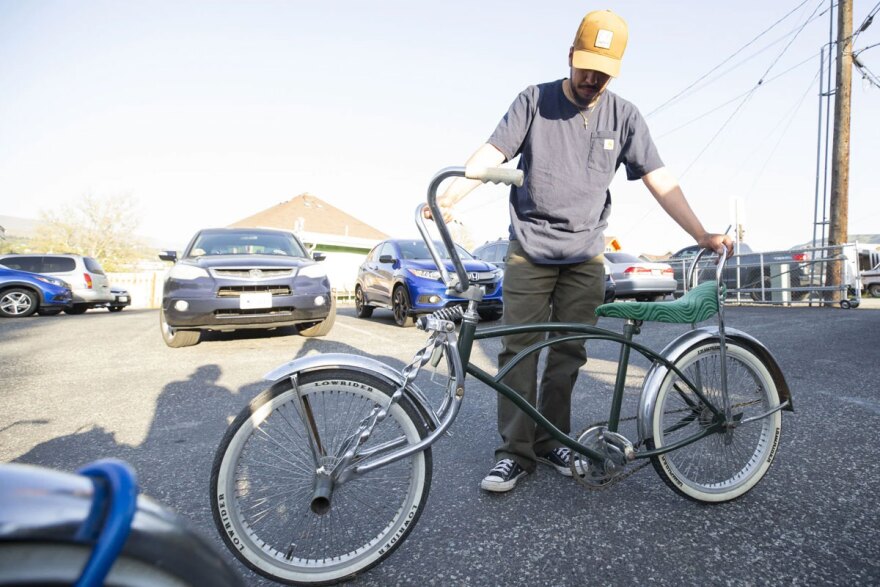 Bryan Morelos holds up a lowrider bicycle Thursday at the Community for the Advancement of Family Education (CAFÉ). (Credit: Jacob Ford / Wenatchee World)