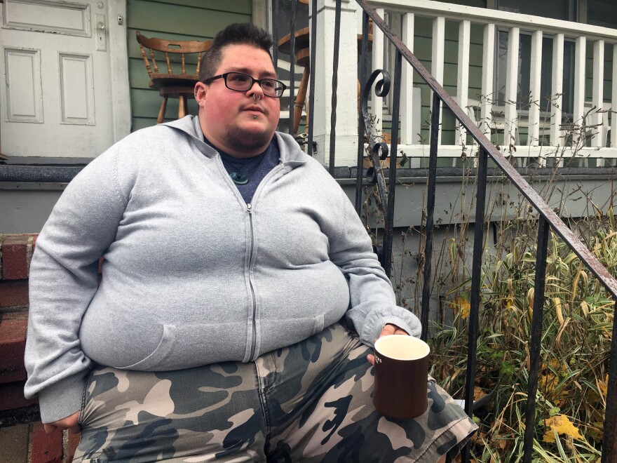 A Rochester native sits on his porch right before going to a name and gender change legal clinic hosted by the Empire Justice Center. 