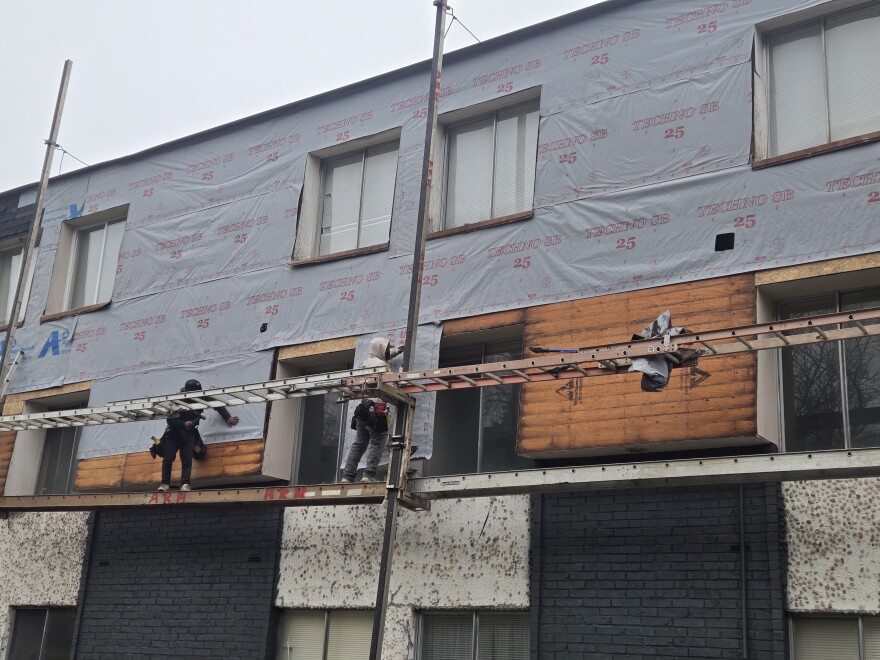 Crews repairing an exterior wall at Kirby Apartments