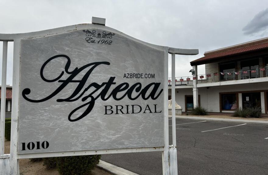 On the left and in the foreground is the sign for Azteca Bridal, with the name of the business being the largest text on it. In the background and to the right, the store can be seen.