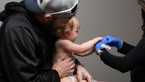 Daren Chandler holds his 12-month-old daughter as she has blood drawn for testing, before receiving a measles shot at Tiger Pediatrics in Easley, S.C., on March 17, 2026. (AP Photo/Mary Conlon)