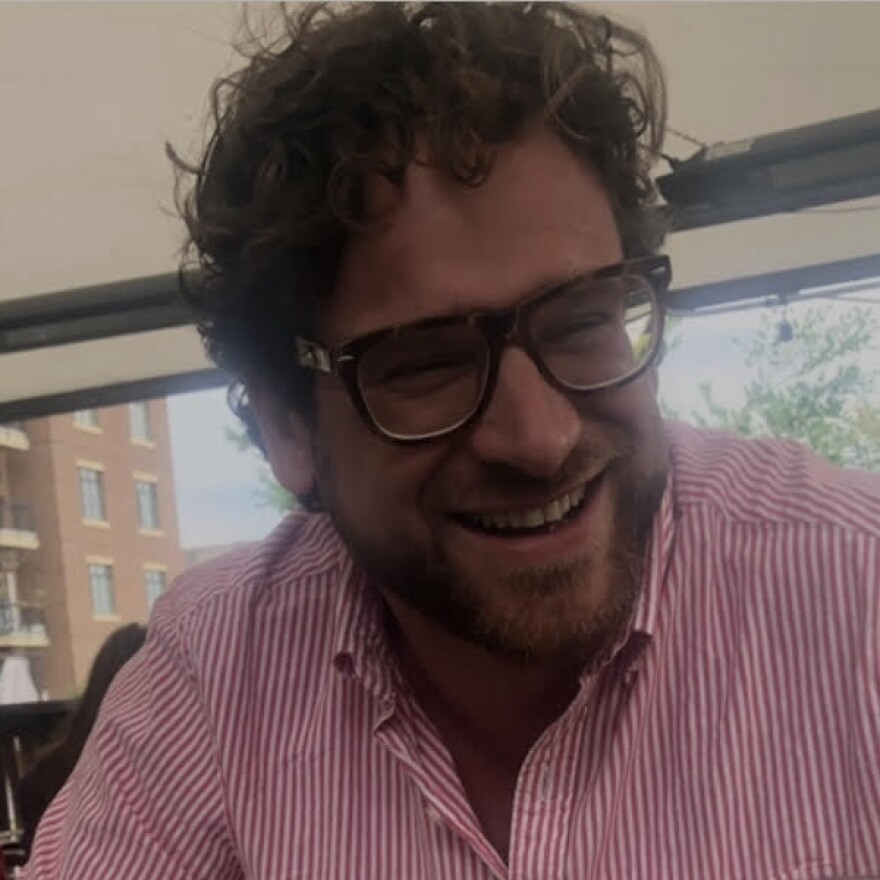 Dave Harrity wearing a striped shirt and eyeglasses, smiling.