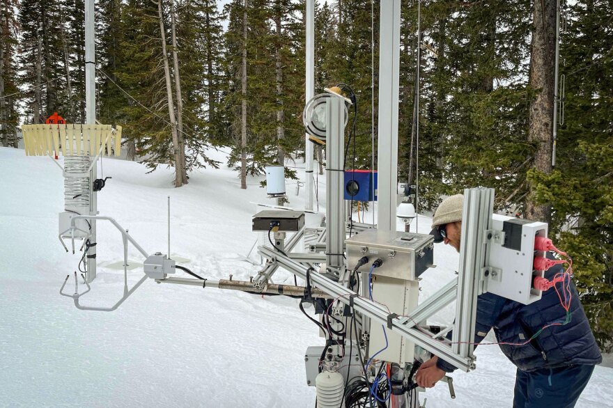 University of Utah student Ryan Szczerbinski examines the Differential Emissivity Imaging Disdrometer installed at Alta near the top of Little Cottonwood Canyon.