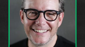 Headshot of Tom Calderone smiling with a green border around the photo over a black-ish background