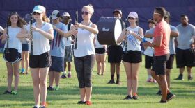 Arjuna Myles, 32, instructs high school marching band students at an afternoon practice. He practices rigorously with bands before competition season. (Camille Graham/WUFT News)