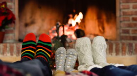 A family enjoys a fire in a fireplace