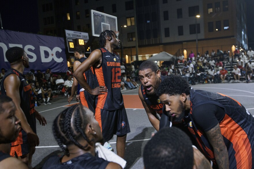 Snuff 317 team member Dereck Seals, Jr., second from right, talks with his team on the bench during a Goodman League basketball game Tuesday, June 24, 2025, in the Barry Farm neighborhood of Washington. (AP Photo/Rod Lamkey, Jr.)