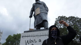 A protester stands in front of a statue of former British prime minister Winston Churchill, with the words (Churchill) "was a racist" written on its base in central London after a demonstration outside the US Embassy. The protest was organized to show solidarity with the Black Lives Matter movement.