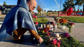 A person places flowers at a makeshift memorial on the other side of Silver Rail Elementary School in Bend, Ore., on Friday, Oct. 16, 2026, a day after a deadly shooting. (AP Photo/Haven Daley)