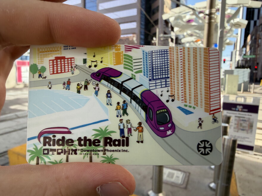 A plastic card featuring illustrations of a light rail, people and buildings