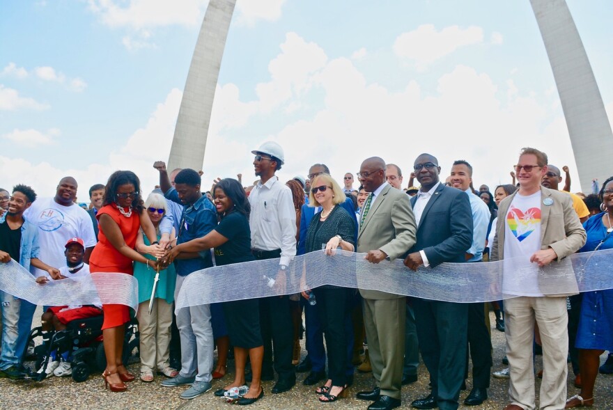 Attendees at Friday's "People's Ribbon Cutting" celebrate near the Gateway Arch grounds in St. Louis.