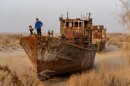 Uzbek children play on a boat in the former Uzbek port town of Moynaq, Nov. 15, 2023. The Aral Sea has receded far away from fishing communities like Moynaq, stranding boats in the surrounding desert.