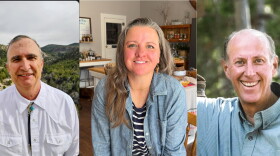Three photos of individual people are set side-by-side in a row. The left photo shows an older white man with greying short hair and thick dark eyebrows. He wears a button down white shirt with a bolo around the collar. Sagebrush and shrubbery are behind him. The center photo is a white woman with light brown hair and grey hair on top. She wears a black and white horizontal striped shirt with a button down blue jean jacket over it. She's in a kitchen and behind her is a table against a wall with one stool, spices on the other wall in a spice rack, a white board with writing on it, a white door with a window in it. Bottles and spice jars are on the table and shelving. The floor is wooden and the walls are a very light grey. The right photo shows a white older man who is balding and has grey short hair. He smiles and is wearing a small blue and white checkered button down shirt. Tree foliage is behind him.