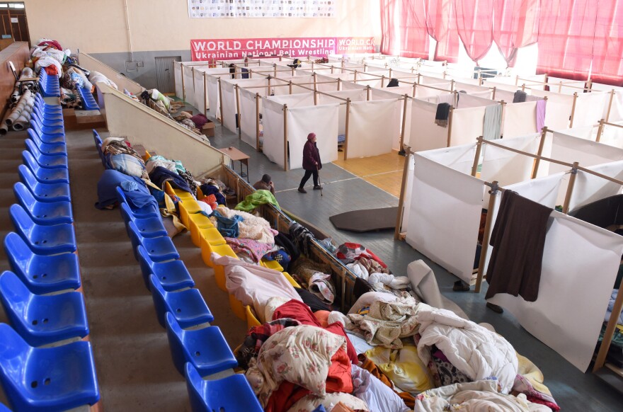 A gym is divided by white sheets on poles