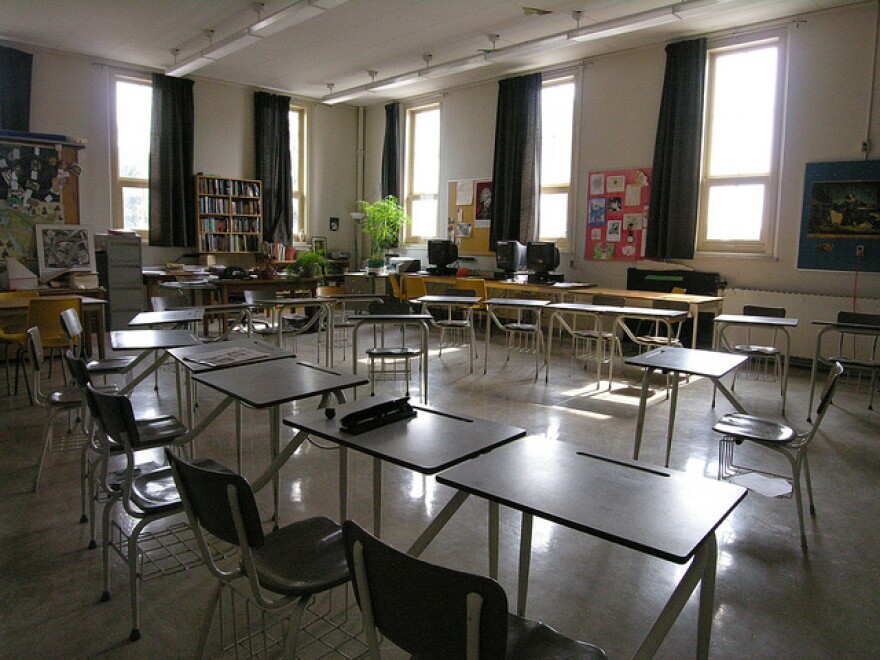 An empty classroom with desks arranged in a square.