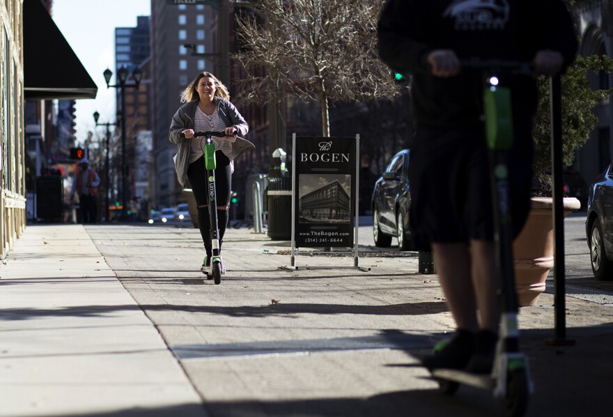 People ride Lime scooters along Washington Avenue in downtown St. Louis Tuesday afternoon. Jan. 8, 2019.