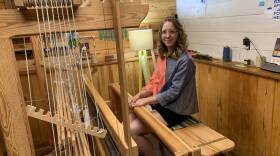 Weaver Christine Novotny sits at the loom in her workshop. (Jon Kalish)