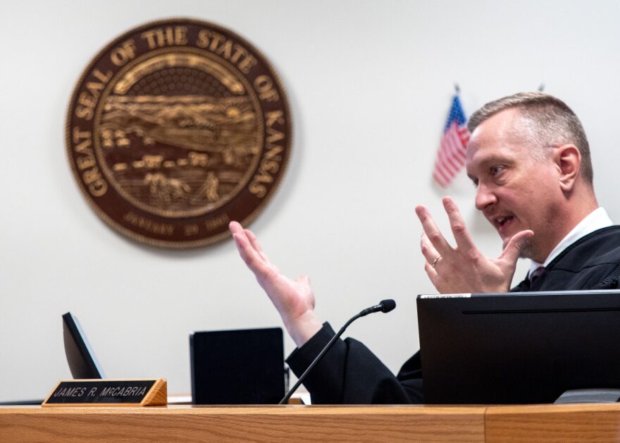 Douglas County District Court Judge James McCabria talks with attorneys during a March 6, 2026, hearing on the Kansas law that restricts transgender individuals to using their biological sex at birth on documents and which bathrooms they use in government buildings.