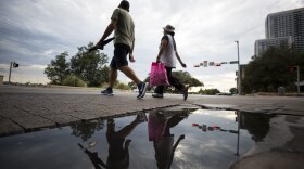 Pedestrians walk along Cesar Chavez. 