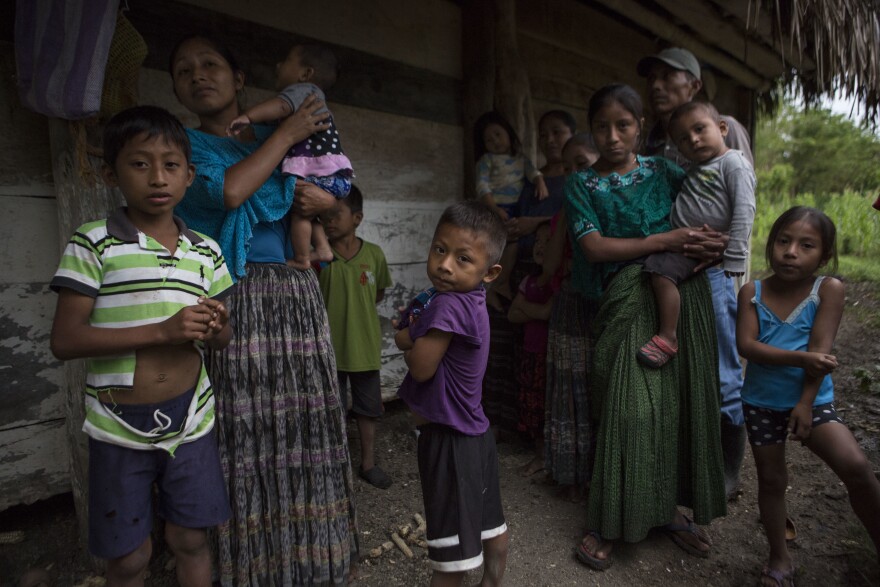 Members of the Caal Maquin family and neighbors stand in front of Claudia Maquin's house in Raxruha, Guatemala, on Saturday, Dec. 15, 2018. 