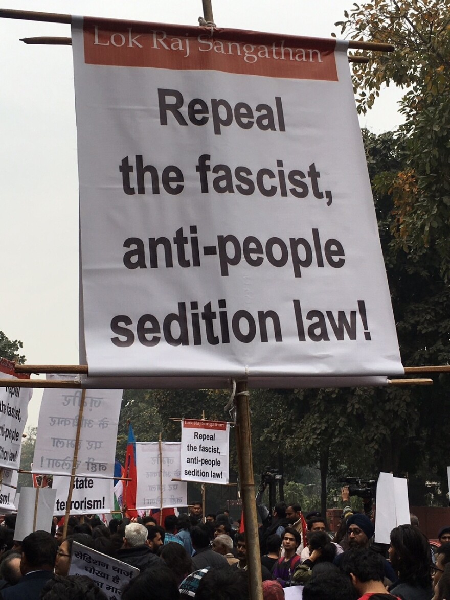 A protester carries a banner calling for a repeal of India's sedition law.