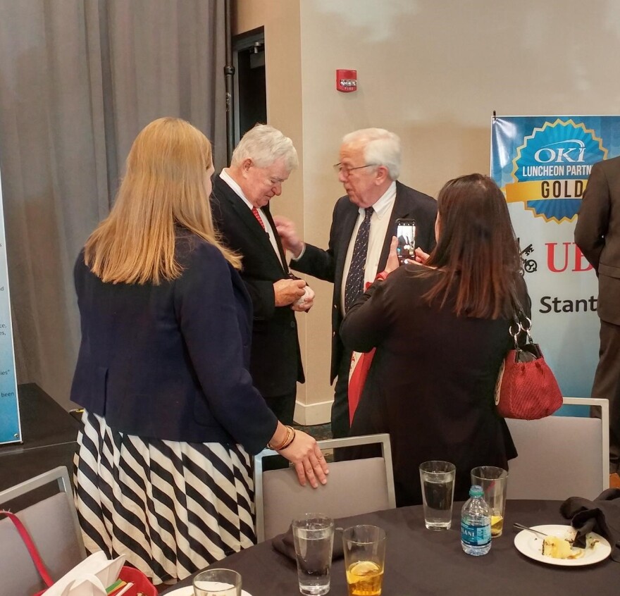 Bob Castellini, (center left), signs a baseball after speaking at the OKI luncheon Tuesday.