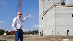 Charles Hurburgh, an agricultural engineering professor at Iowa State University, stands at the site of the Kent Corporation Feed Mill and Grain Science Complex. He points to the feed mill tower, which is more than 100 feet tall.  The complex is expected to be completed in fall 2022. It will make feed for livestock and train students who want to work in the feed and grain industry.