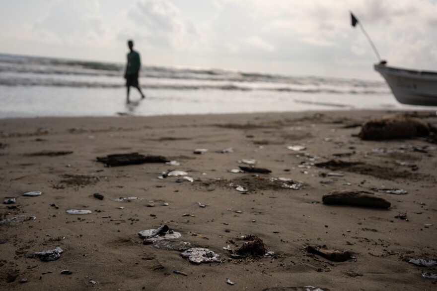 Clumps of oil residue lie on the shore after fishing outings were suspended because of an oil spill that Mexican authorities said originated from an unidentified vessel and two natural oil seeps along the Gulf coast in Salinas, Mexico, Thursday, March 26, 2026.
