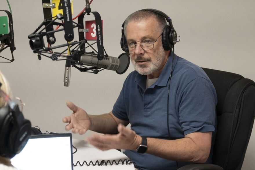 An image of a man sitting behind a microphone at KCUR