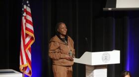 A woman standing in front of a podium holding an award