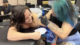 Moony Valdes works on a tattoo of a heart. (Image: Laura Philion)