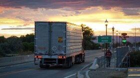 A semi truck travels west along Main Street and over the Green River at sunset in Green River, Utah, Aug. 18, 2024.