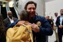 Gov. Ron DeSantis greets a passenger who evacuated from Israel early Friday morning at Tampa International Airport.