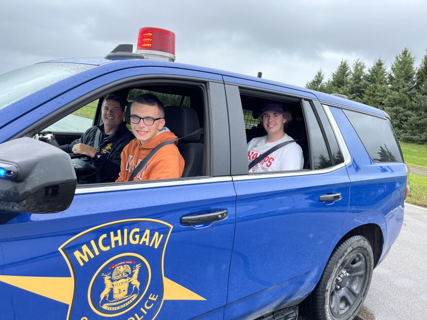 Teens and a trooper in an MSP patrol car