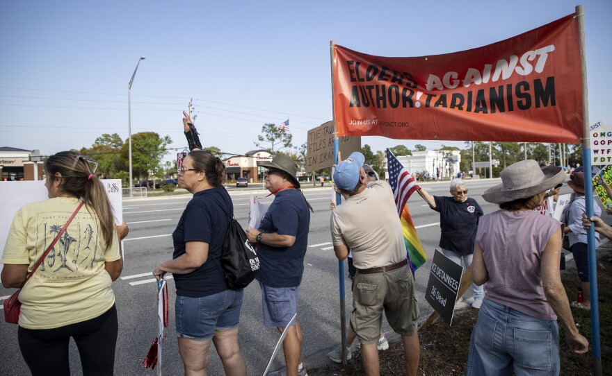 Protesters line U.S. 41 near Daniels Parkway on Saturday, March 28, 2026, for the No Kings rally.