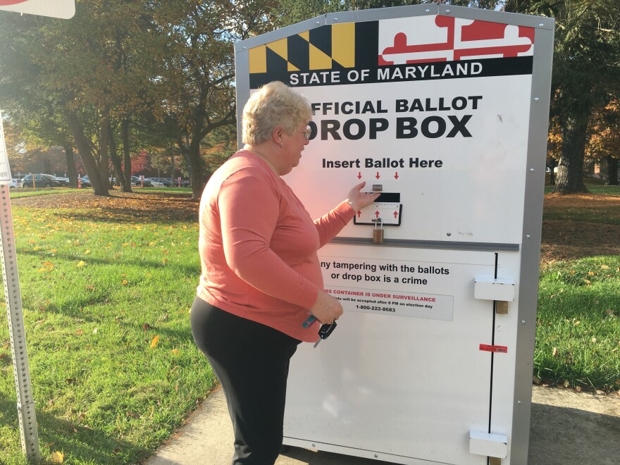 A Maryland voter drops off a ballot in a Baltimore County drop box.