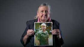 Mary Ellen Shugart holds a portrait of herself as a young Army nurse in Vietnam.