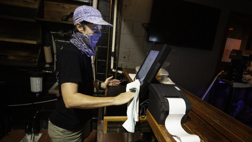 Tamara Hoover, co-owner of Cheer Up Charlie's, cleans behind the bar a week before opening.