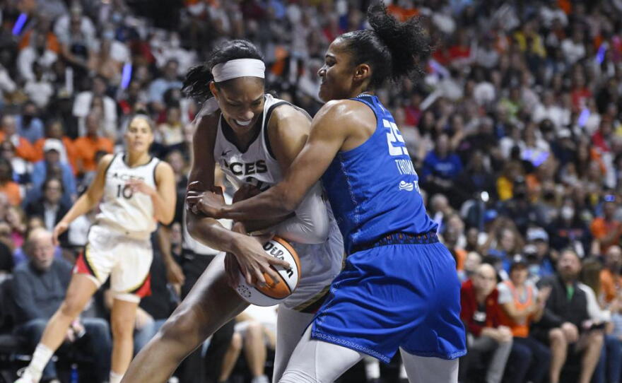 The Las Vegas Aces' A'ja Wilson (left) is pressured by the Connecticut Sun's Alyssa Thomas (right)) during the first half in Game 4 of the WNBA basketball Finals, Sunday, Sept. 18, 2022, in Uncasville, Conn.