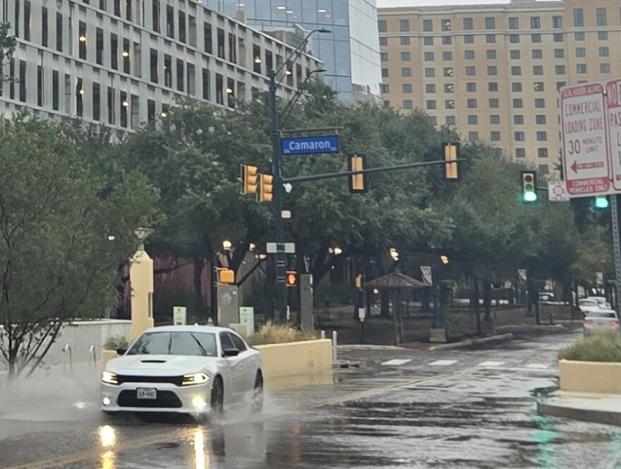 A car splashes its way down Houston Street downtown on Oct. 1, 2026