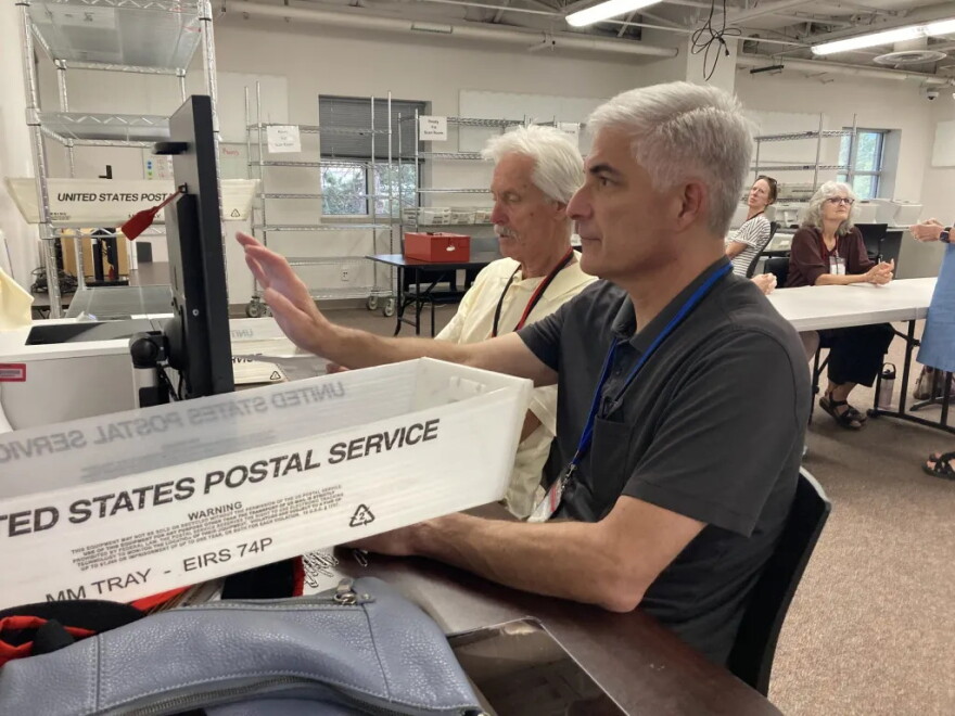 Democratic election judge Greg Pine fills out a ballot to replace one that was returned rumpled and unable to be scanned on July 9, 2026, in Boulder County as Republican judge Randy Paddock read the votes aloud from the damaged ballot.
