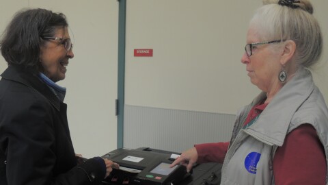 Barb Norbeck and Marie Weller review the process of submitting ballots at the Challenger Learning Center on Tuesday.