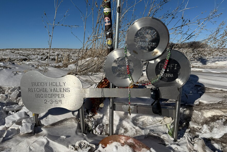A metal memorial marks the site of the plane crash in the farm field on a snowy day.