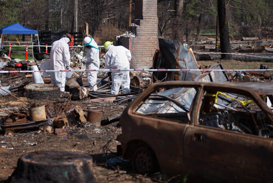 Crews work to clear hazardous waste from burned properties.