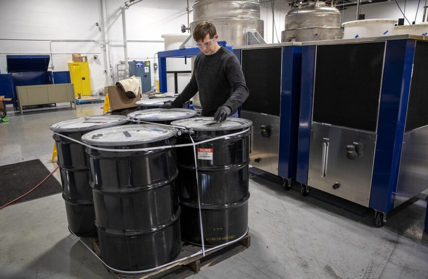 Eric Gratz, the cofounder and CTO of Ascend elements looks over barrels of black powder, or black mass, the ground up product of lithium batteries ready for recycling.