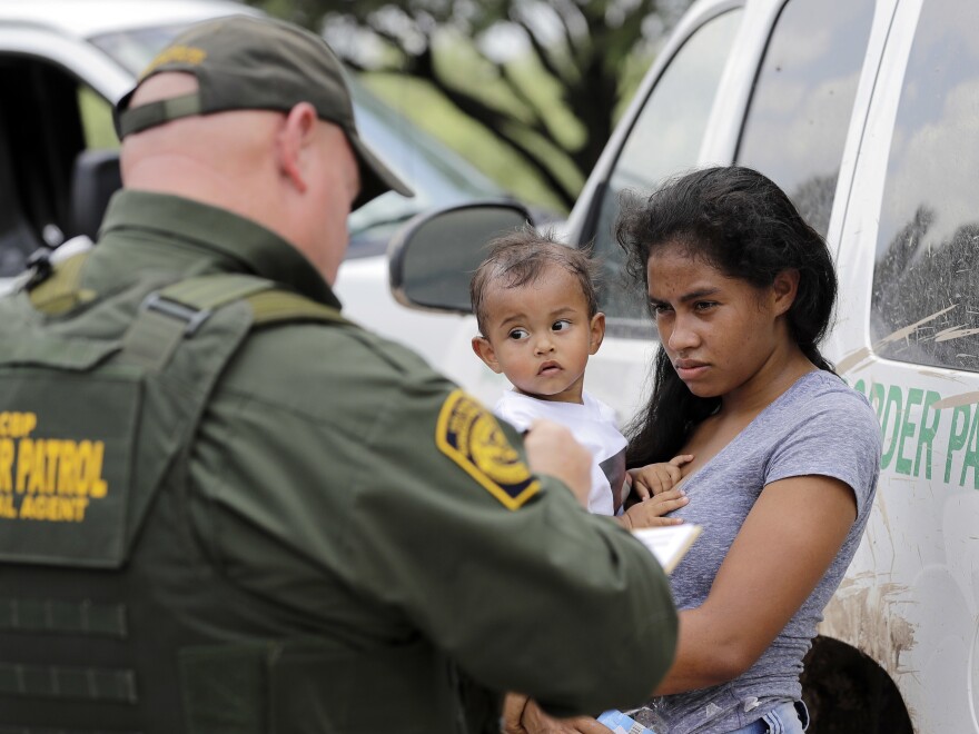 President Trump's zero tolerance policy left the CBP struggling to process the number of people it detained — and the agency says it will temporarily stop turning immigrant parents over to prosecutors. Here, a mother migrating from Honduras holds her 1-year-old child as she surrenders to border agents on Monday. The two had illegally crossed the border near McAllen, Texas.