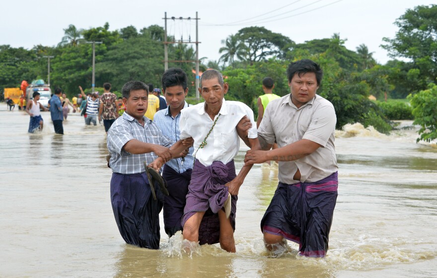 Central Myanmar residents negotiate a flooded road after waters submerged villages.