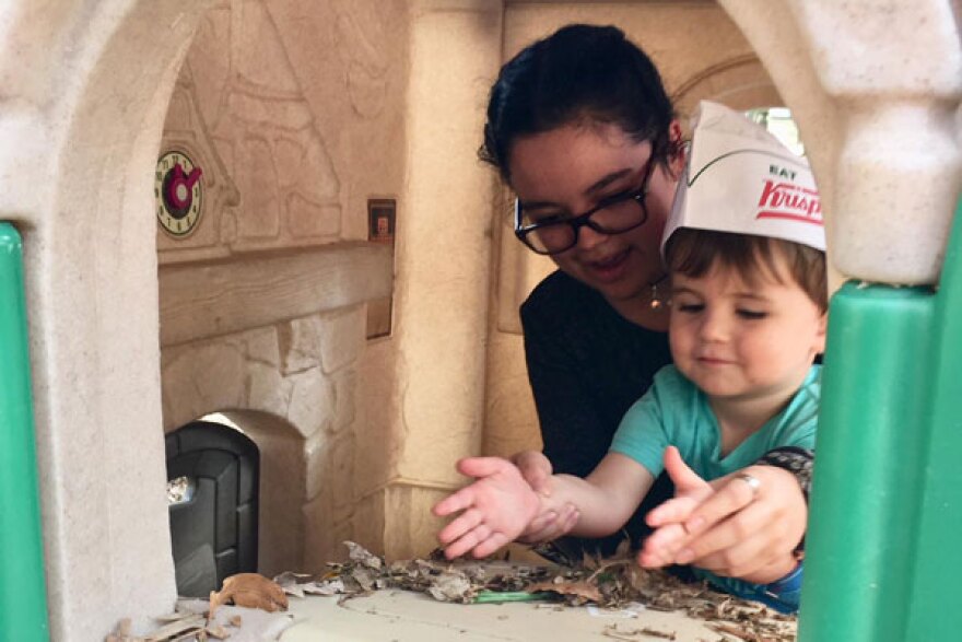 With help from his nanny, Poulleth Jimenez, 2-year-old Jack Helton runs a donut shop out of his plastic green and beige playhouse.