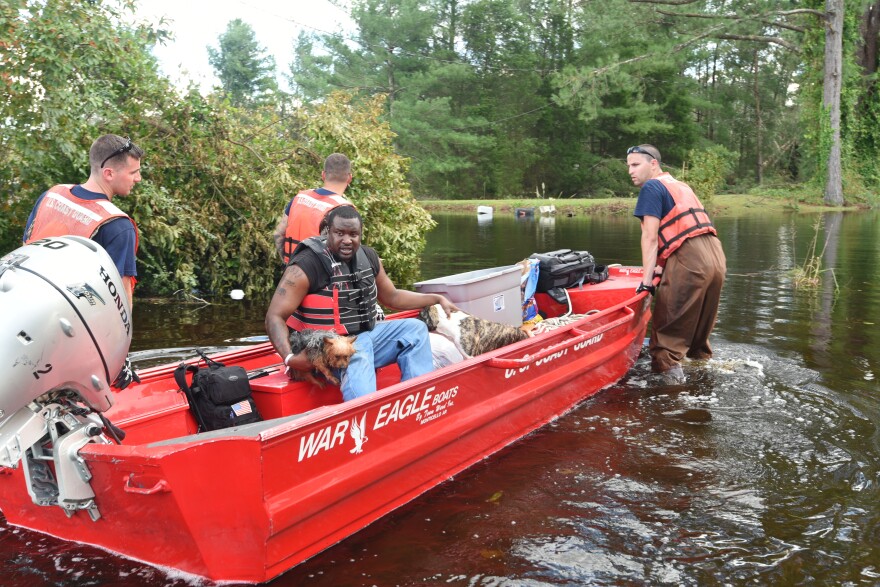 A Coast Guard crew transports Bernard Jones through the flooded streets of Pollocksville, N.C. September 18, 2018 after Hurricane Florence. Seven years after the storm, the town was planning to use a FEMA grant to elevate still-empty buildings downtown.